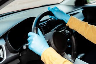 Blue gloves on a steering wheel.