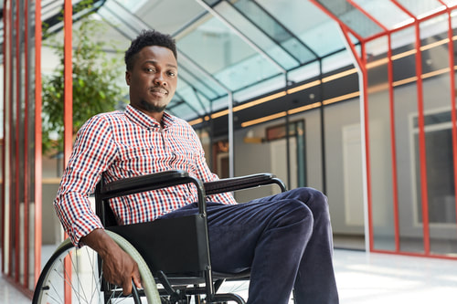 African- American can man sitting on a wheelchair and smilling.