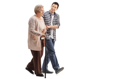Picture of a young man accompanying a female senior citizen who is holding a cane.